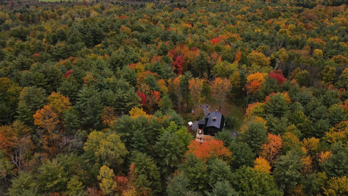 Aerial view of the cabin surrounded by orange and red fall foliage